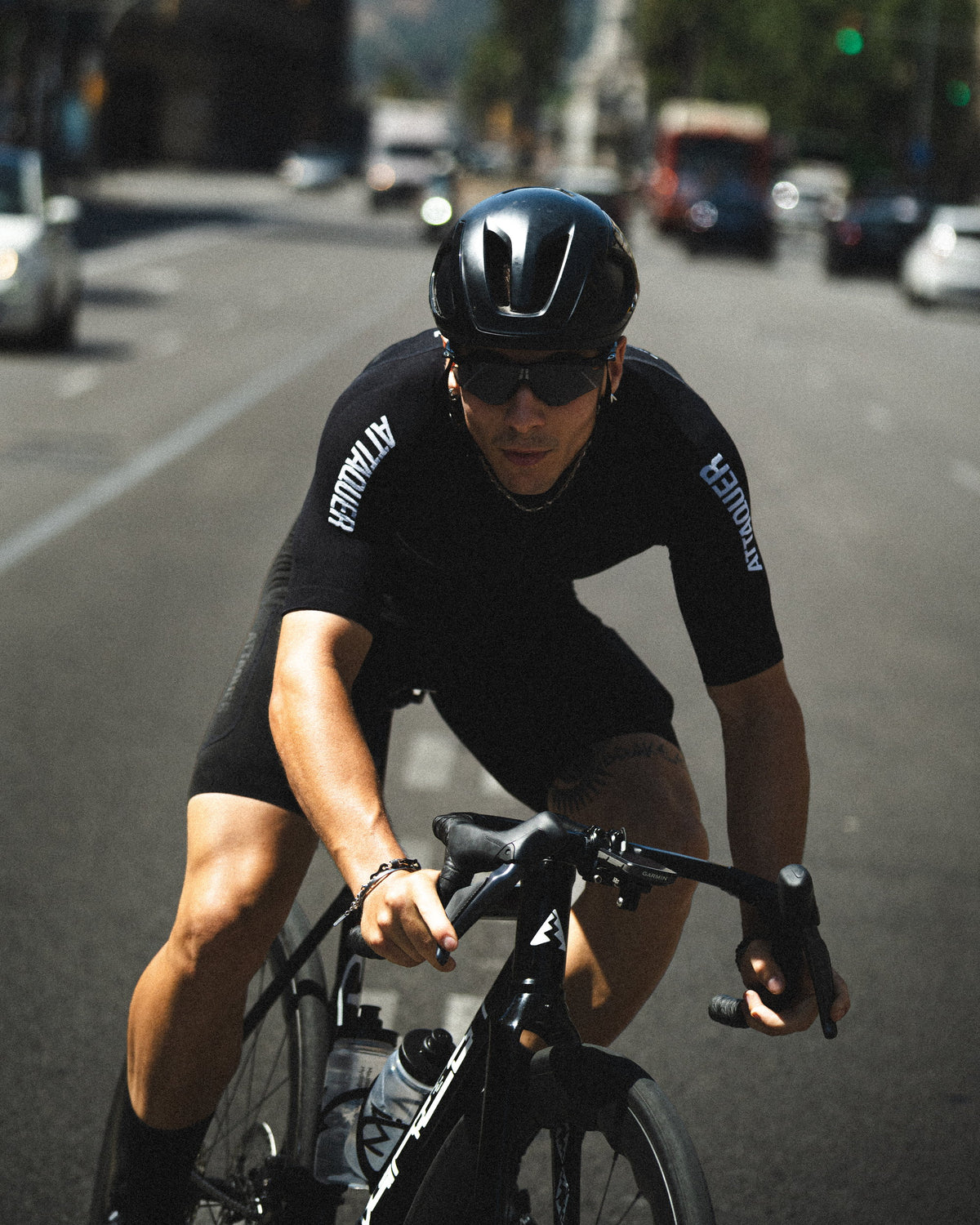 Attaquer rider in black Attaquer kit riding through city traffic