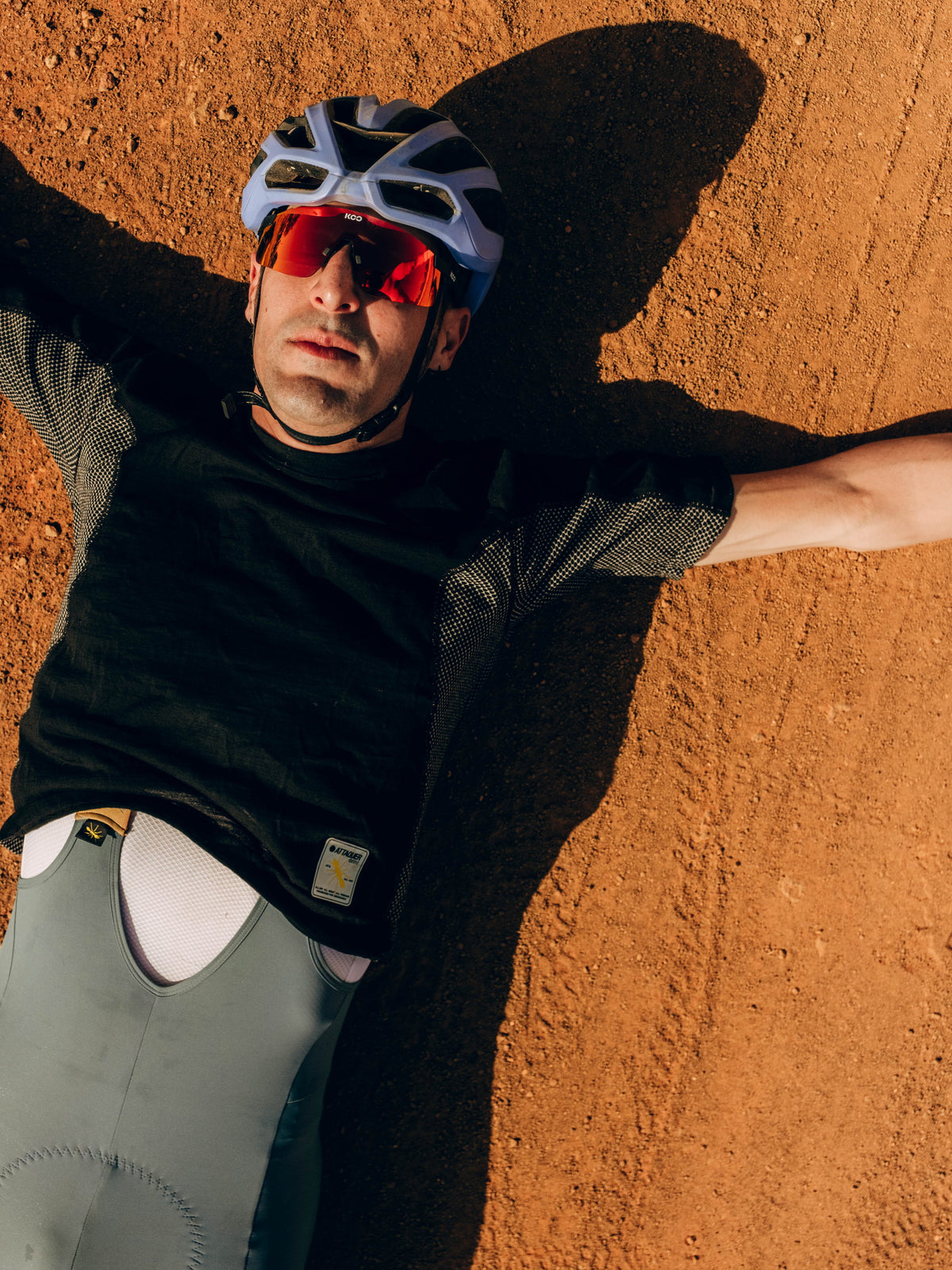 Attaquer rider lying on red earth in Senegal wearing Attaquer kit