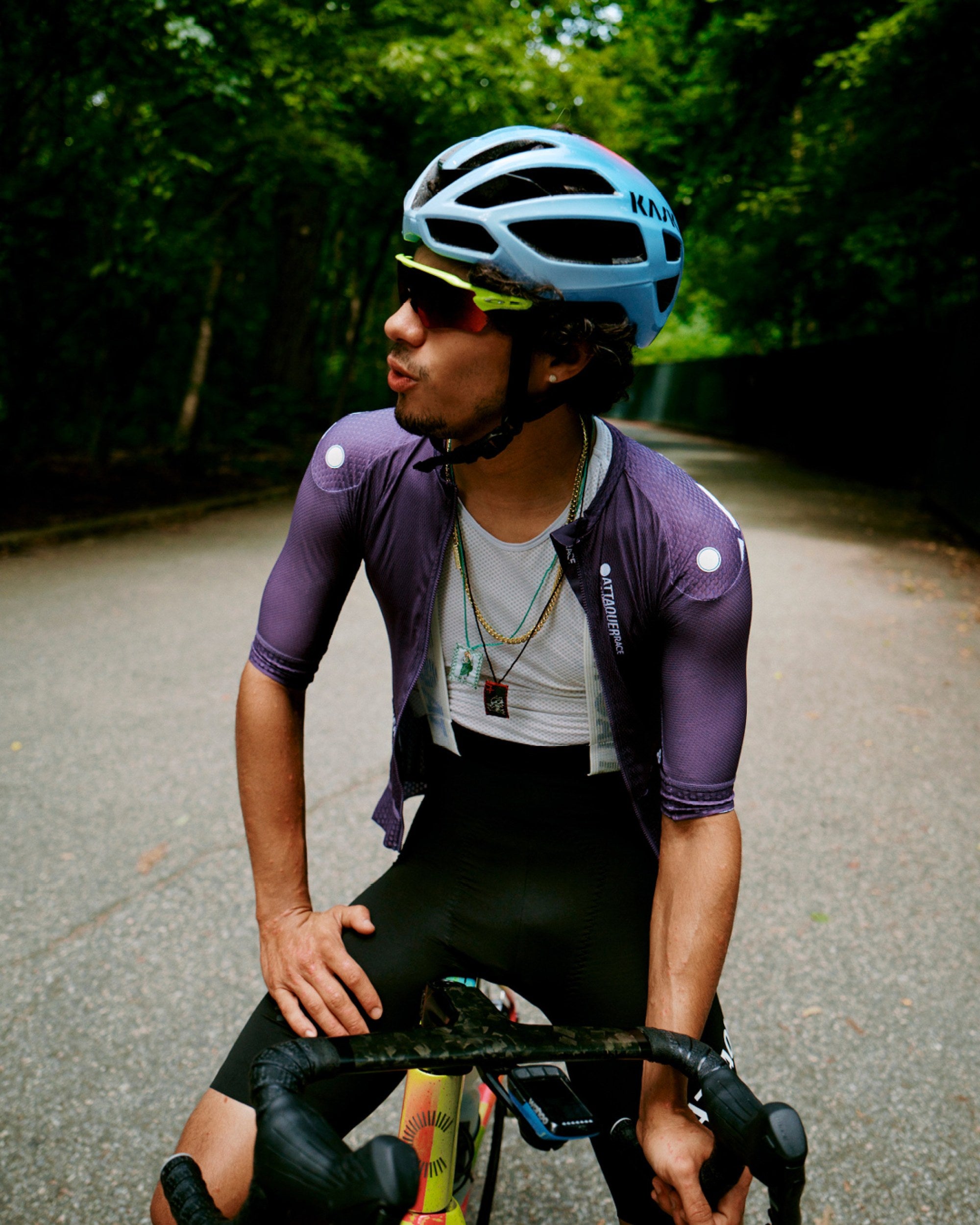 Attaquer rider in Race kit on a tree-lined road